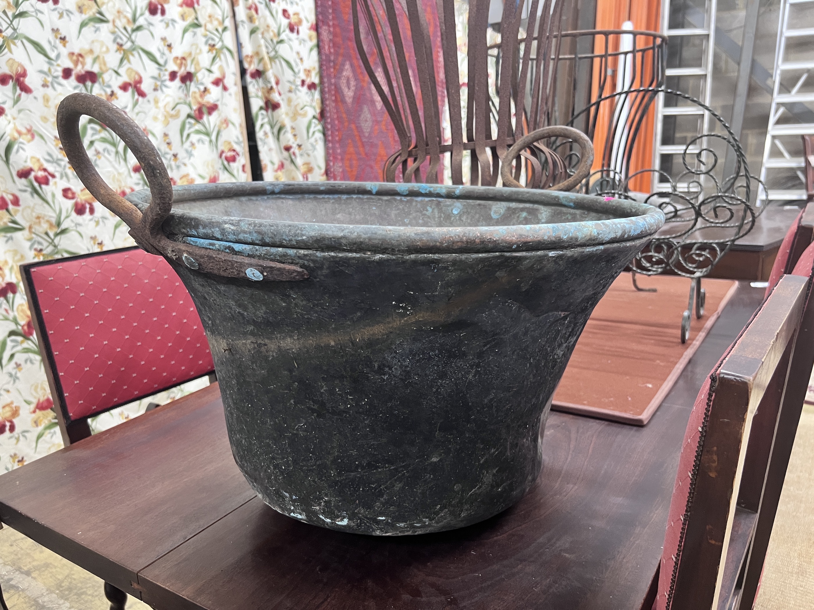 A pair of wrought iron circular garden frames, a magazine rack and a copper cauldron, largest height 78cm